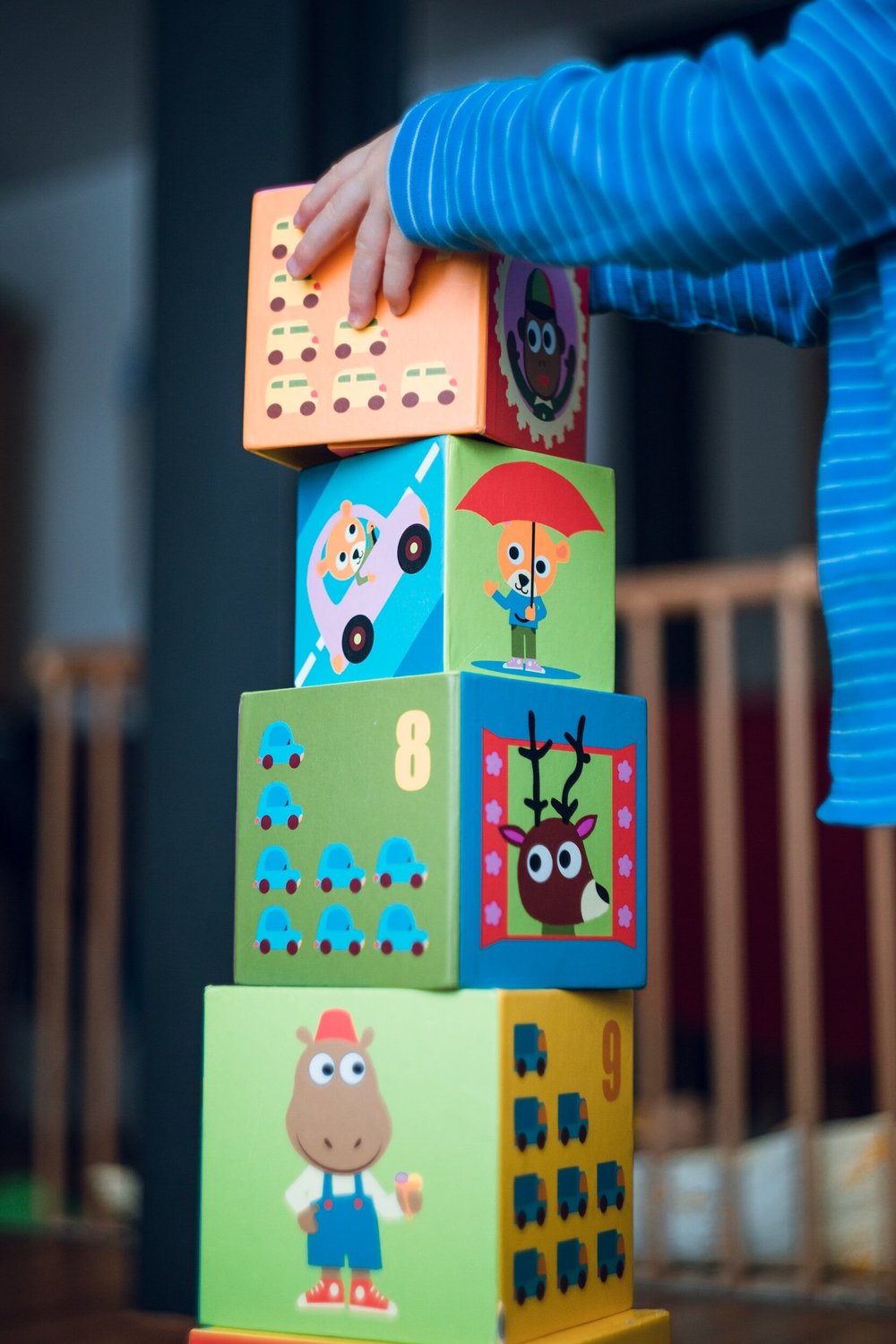 A young child stacking colourful picture blocks into a tower