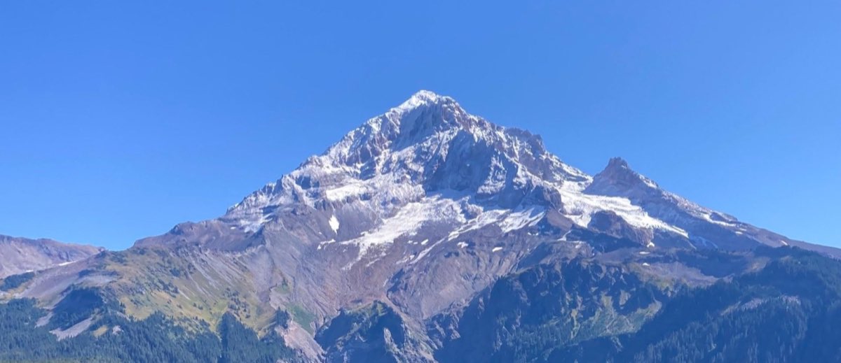 A snow-capped mountain peak against a clear blue sky